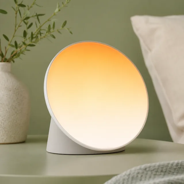 Sunrise alarm clock lamp on a bedside table
